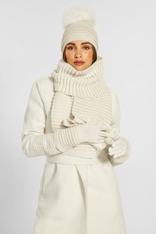 Sentaler Adult Ribbed Hat With Oversized Fur Pompon, Ribbed Scarf and Ribbed Gloves crafted in Baby Alpaca and in Ivory. Seen from front on model.