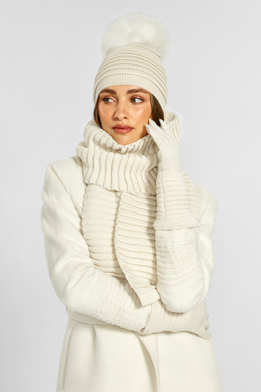 Sentaler Adult Ribbed Hat With Oversized Fur Pompon, Ribbed Scarf and Ribbed Gloves crafted in Baby Alpaca and in Ivory. Seen from front on model.
