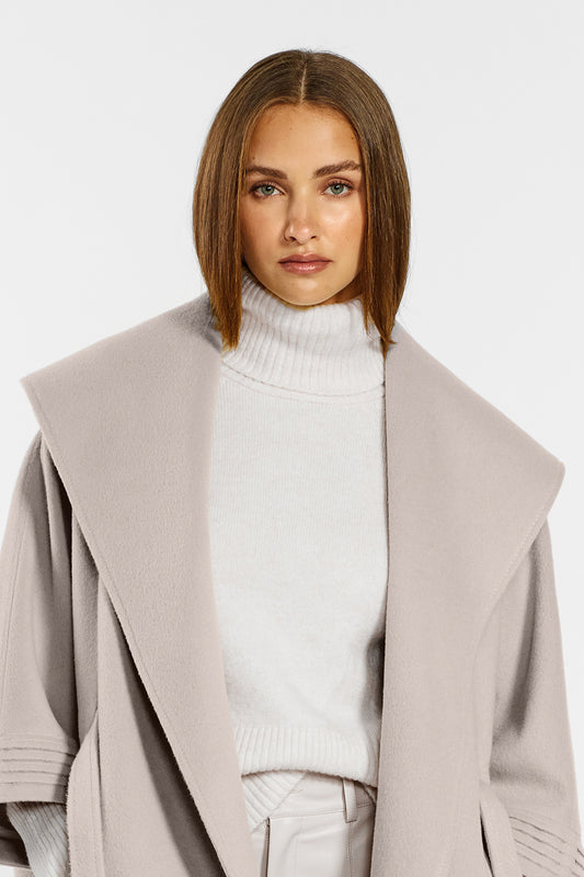 Sentaler Cape with Shawl Collar and Belt crafted in Baby Alpaca wool and in Bleeker Beige. Seen from front open close up on female model.