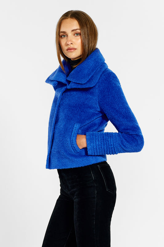 Sentaler Bouclé Alpaca Moto Jacket with Signature Double Collar featured in Bouclé Alpaca and available in Cobalt Blue. Seen from side above the knees on female model.