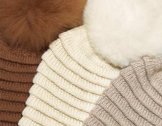 Sentaler 2021 Gift Guide featuring Close Up of Women's Ribbed Hat with Oversized Fur Pompon in Assorted Neutral Colours.