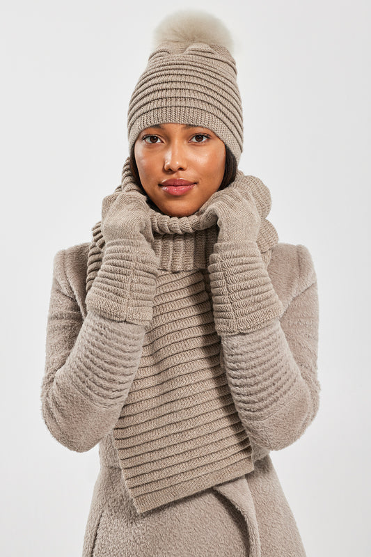 Sentaler Adult Ribbed Hat With Oversized Fur Pompon featured in Baby Alpaca and available in Light Taupe. Seen with scarf and gloves 1.