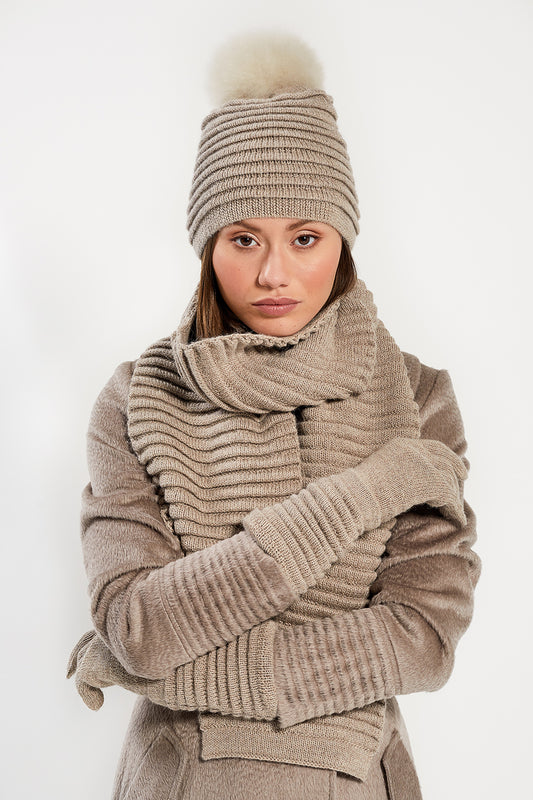 Sentaler Adult Ribbed Hat With Oversized Fur Pompon featured in Baby Alpaca and available in Light Taupe. Seen with scarf and gloves 2.