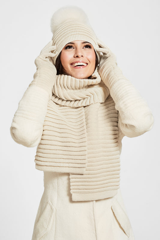Sentaler Adult Ribbed Hat With Oversized Fur Pompon, Ribbed Scarf and Ribbed Gloves featured in Baby Alpaca and available in Ivory. Seen from front on model.