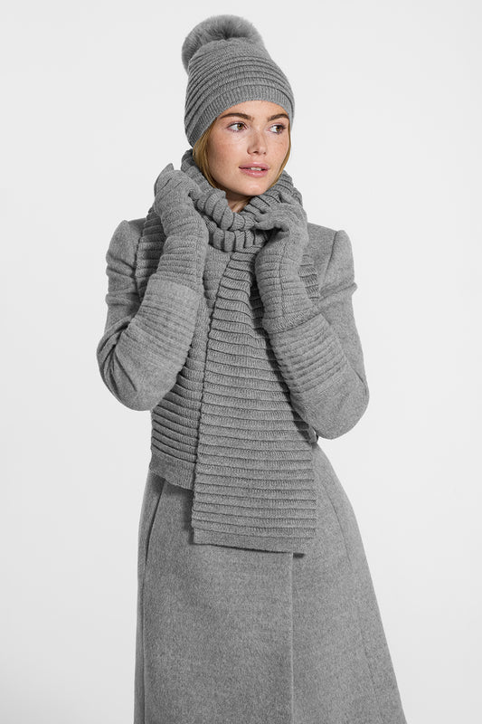 Sentaler Adult Ribbed Hat With Oversized Fur Pompon, Ribbed Scarf and Ribbed Gloves featured in Baby Alpaca and available in Grey. Seen from side on model.