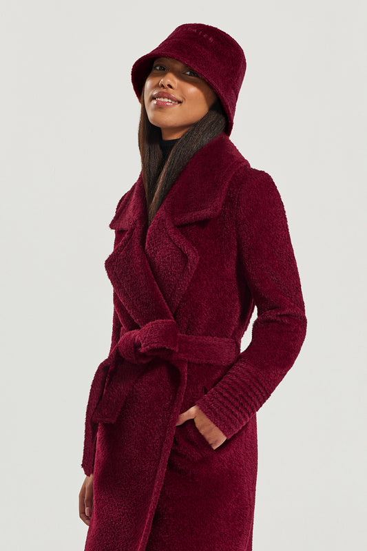 Sentaler Bouclé Alpaca Bucket Hat featured in Bouclé Alpaca and available in Garnet Red. Seen from side above the knee.