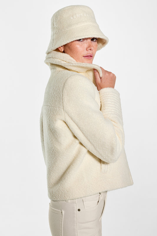 Sentaler Bouclé Alpaca Moto Jacket with Signature Double Collar and Bucket Hat featured in Bouclé Alpaca and available in Ivory. Seen from side above the knees on model.