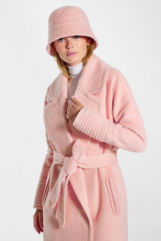 Sentaler Bouclé Alpaca Bucket Hat featured in Bouclé Alpaca and available in Pink Clay. Seen from front above the knees on model.