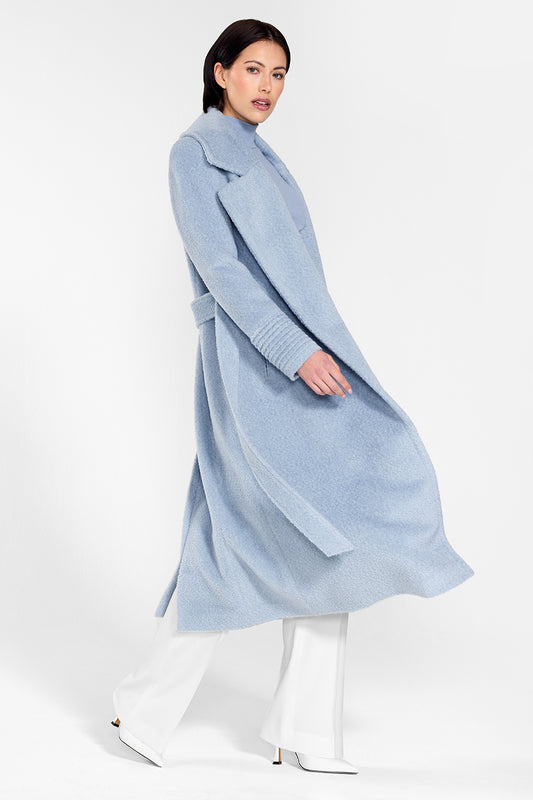 Sentaler Bouclé Alpaca Long Notched Collar Wrap Coat featured in Bouclé Alpaca and available in Powder Blue. Seen from side on female model wearing the coat open while walking.