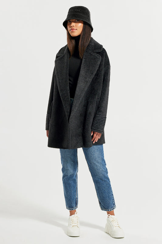 Sentaler Bouclé Alpaca Bucket Hat and Bouclé Alpaca Mid Length Oversized Notched Collar Coat featured in Bouclé Alpaca and available in Black. Seen from front on model.