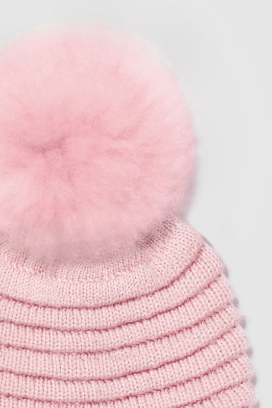 Sentaler Kids (1-5 Years) Ribbed Hat with Oversized Fur Pompon featured in Baby Alpaca and available in Pink. Seen as off figure close up.