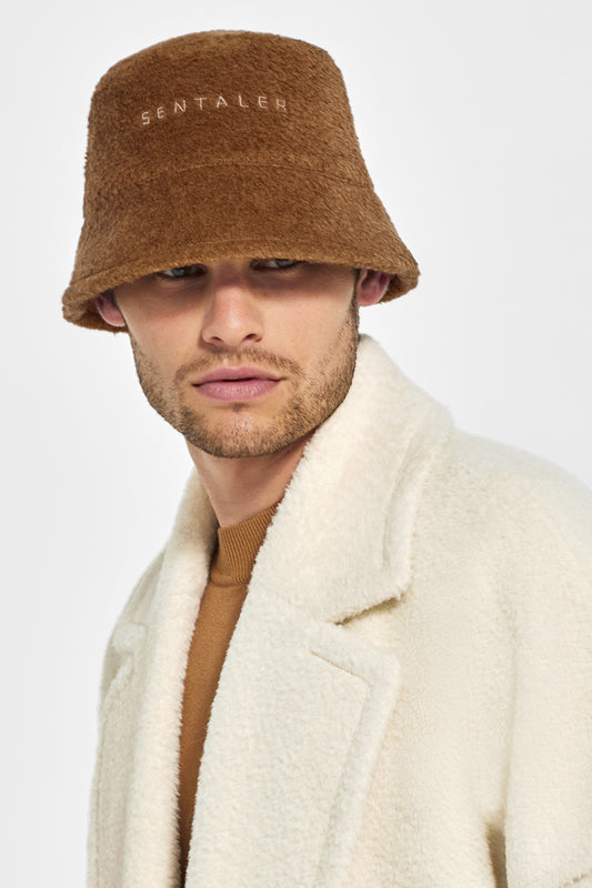 Sentaler Mens Bouclé Alpaca Bucket Hat featured in Bouclé Alpaca and available in Caramel Café. Seen from front close up on model.