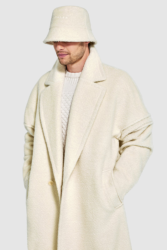 Sentaler Mens Bouclé Alpaca Bucket Hat featured in Bouclé Alpaca and available in Ivory. Seen from side above waist on model.
