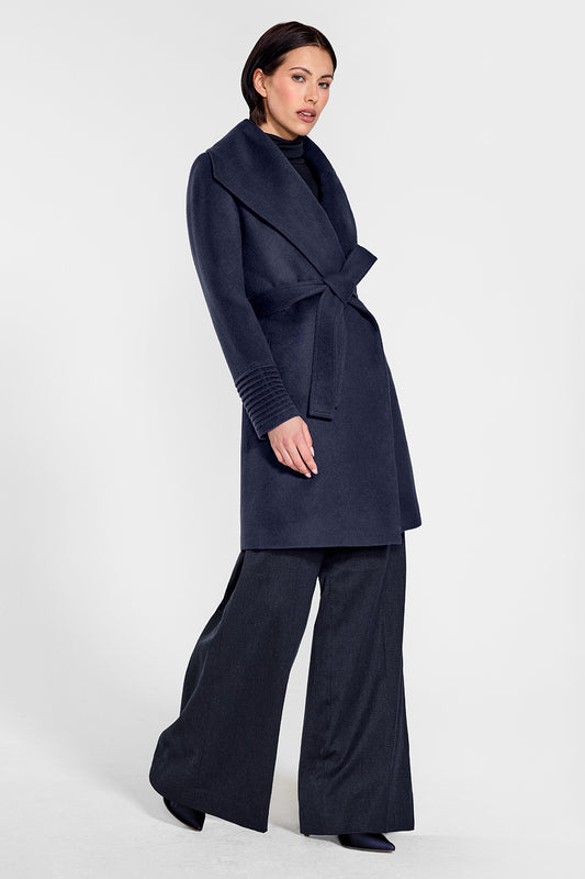 Sentaler Mid Length Shawl Collar Wrap Coat featured in Baby Alpaca and available in Deep Navy. Seen from side on female model who is wearing the coat belted.